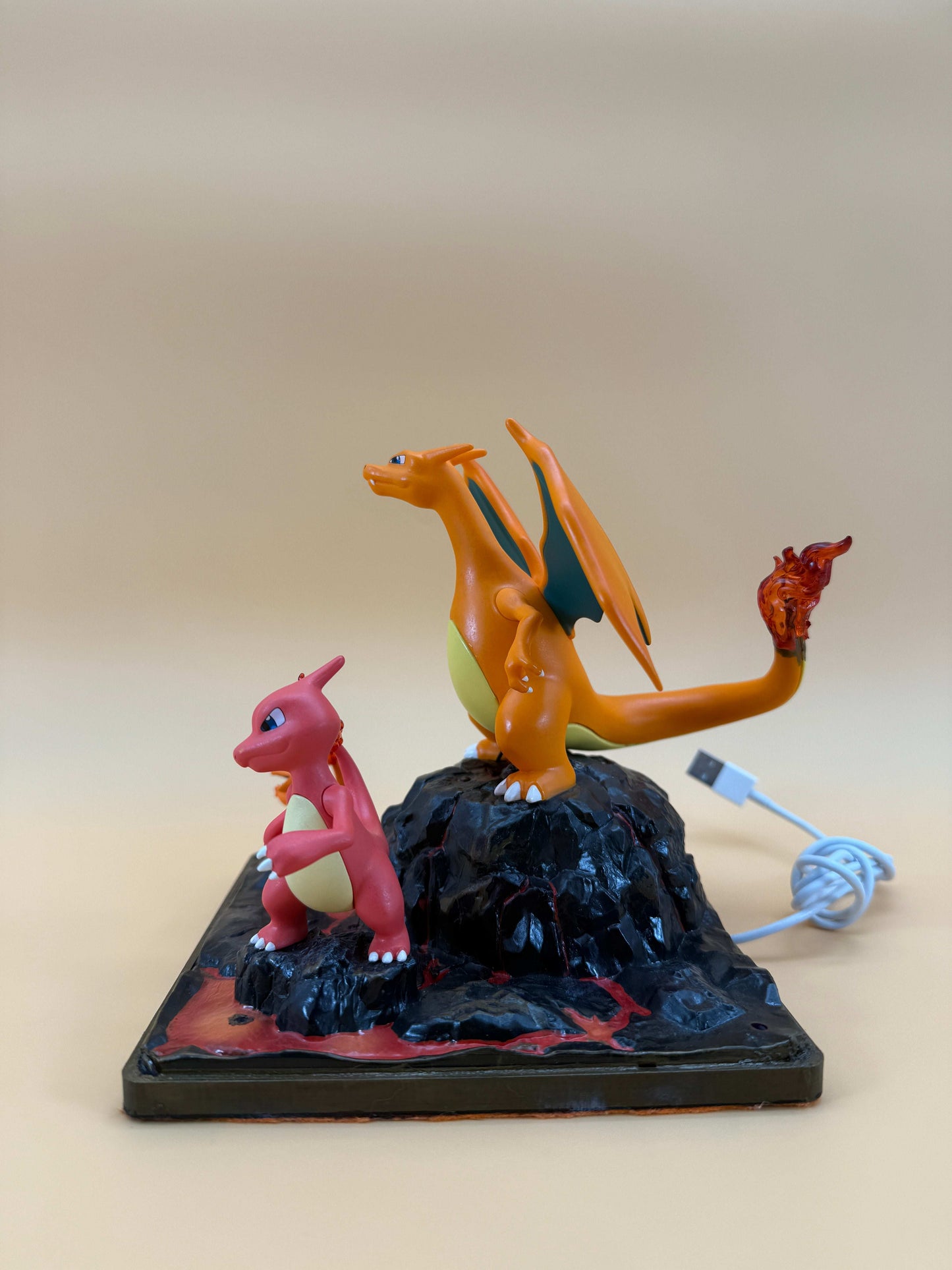 Charizard and Charmeleon desk lamp with USB cord on a square base.