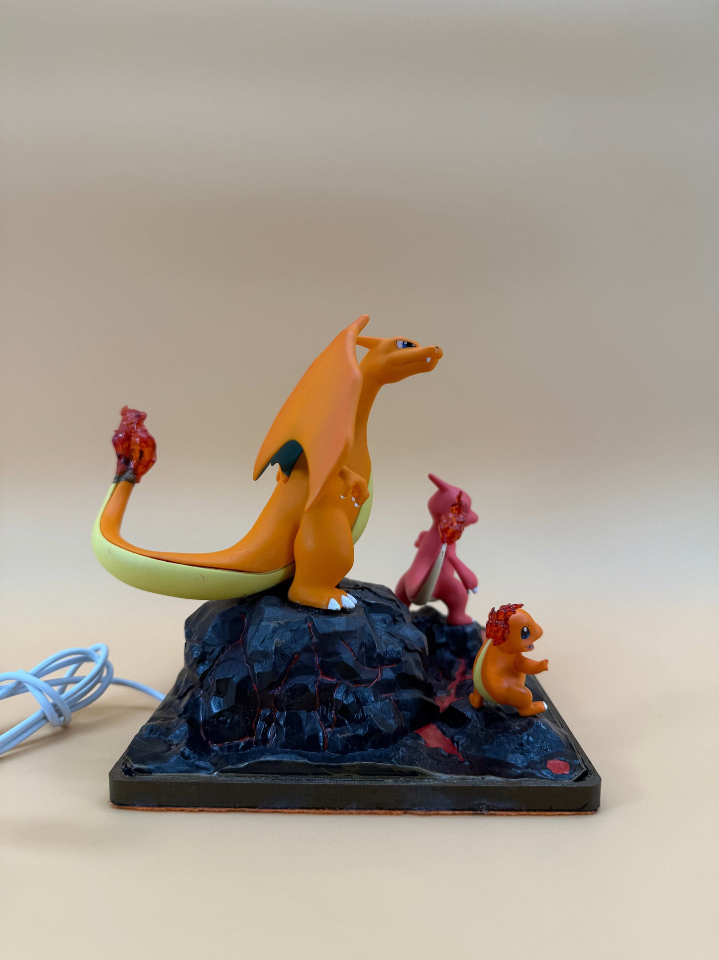 6" Charizard, Charmeleon, Charmander statue desk lamp with USB cord on a square base.
