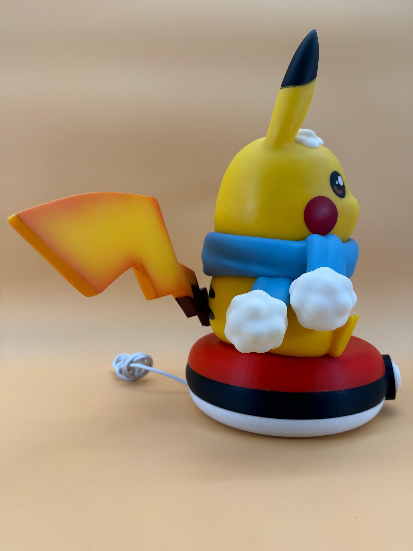 Winter Pikachu Pokeball desk lamp with USB cord, featuring a cute Pikachu in winter attire on a Pokeball base.