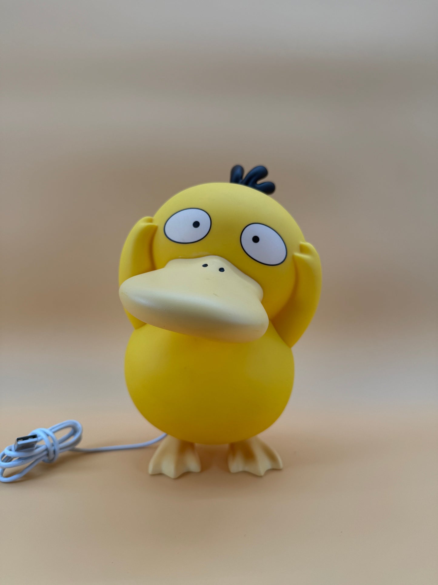 8" Psyduck Statue Pokemon USB Desk Lamp Light on beige background.