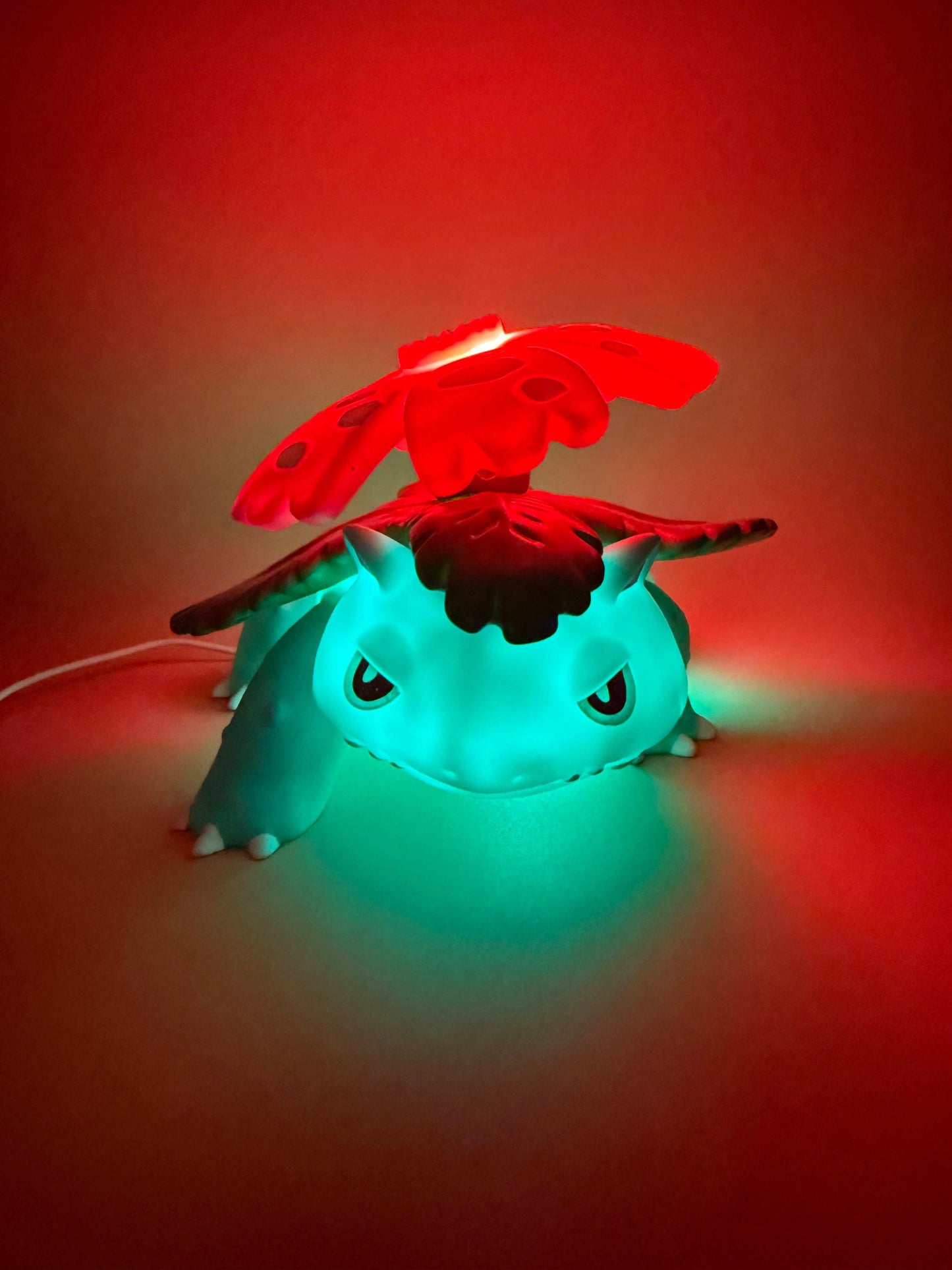 5" x 7" Venusaur statue desk lamp with USB cord, glowing with vibrant colors.