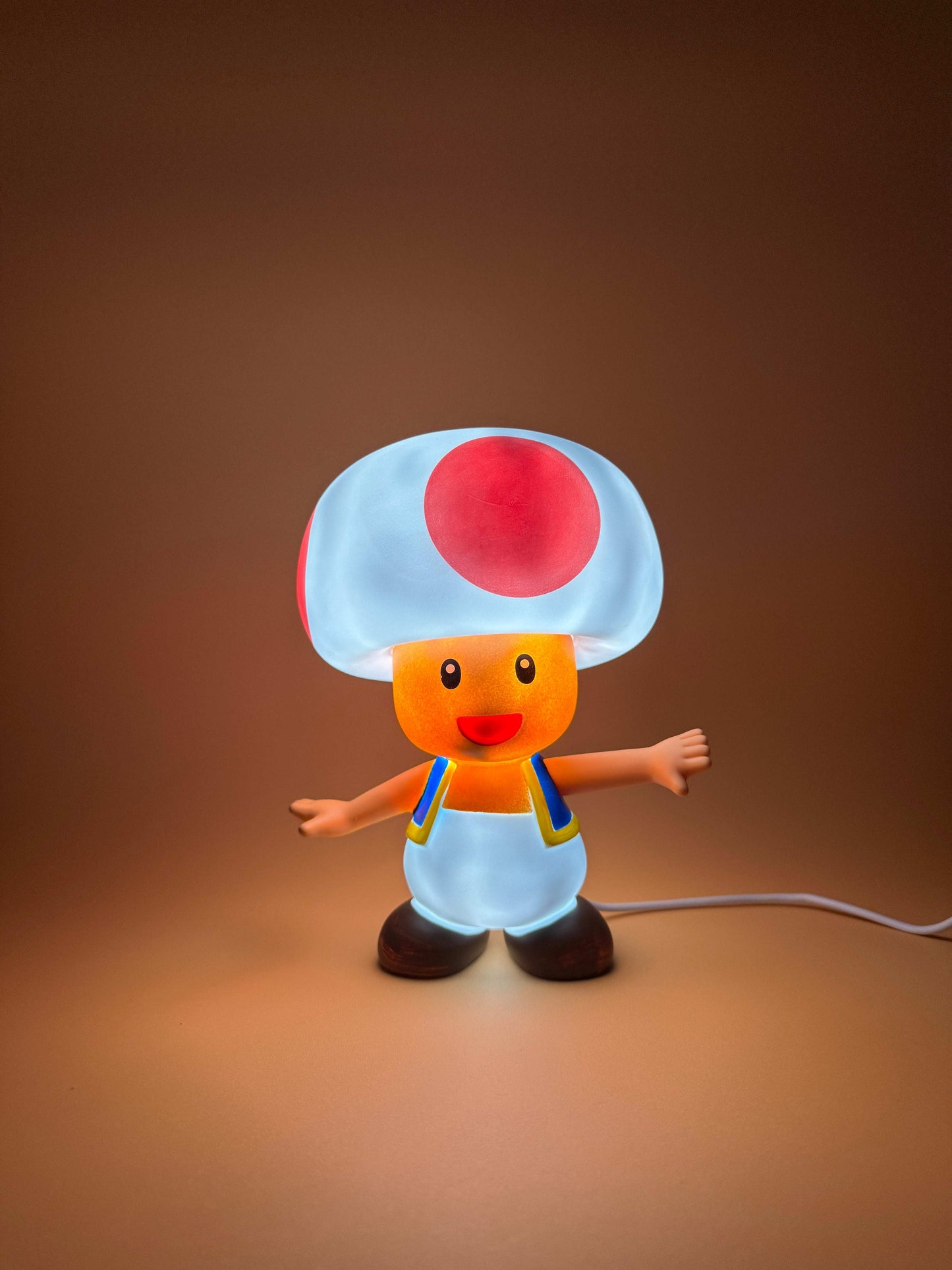 6" Toad USB Desk Lamp with built-in USB cord, illuminating a vibrant Toad figure, perfect for adding a magical touch to any space.