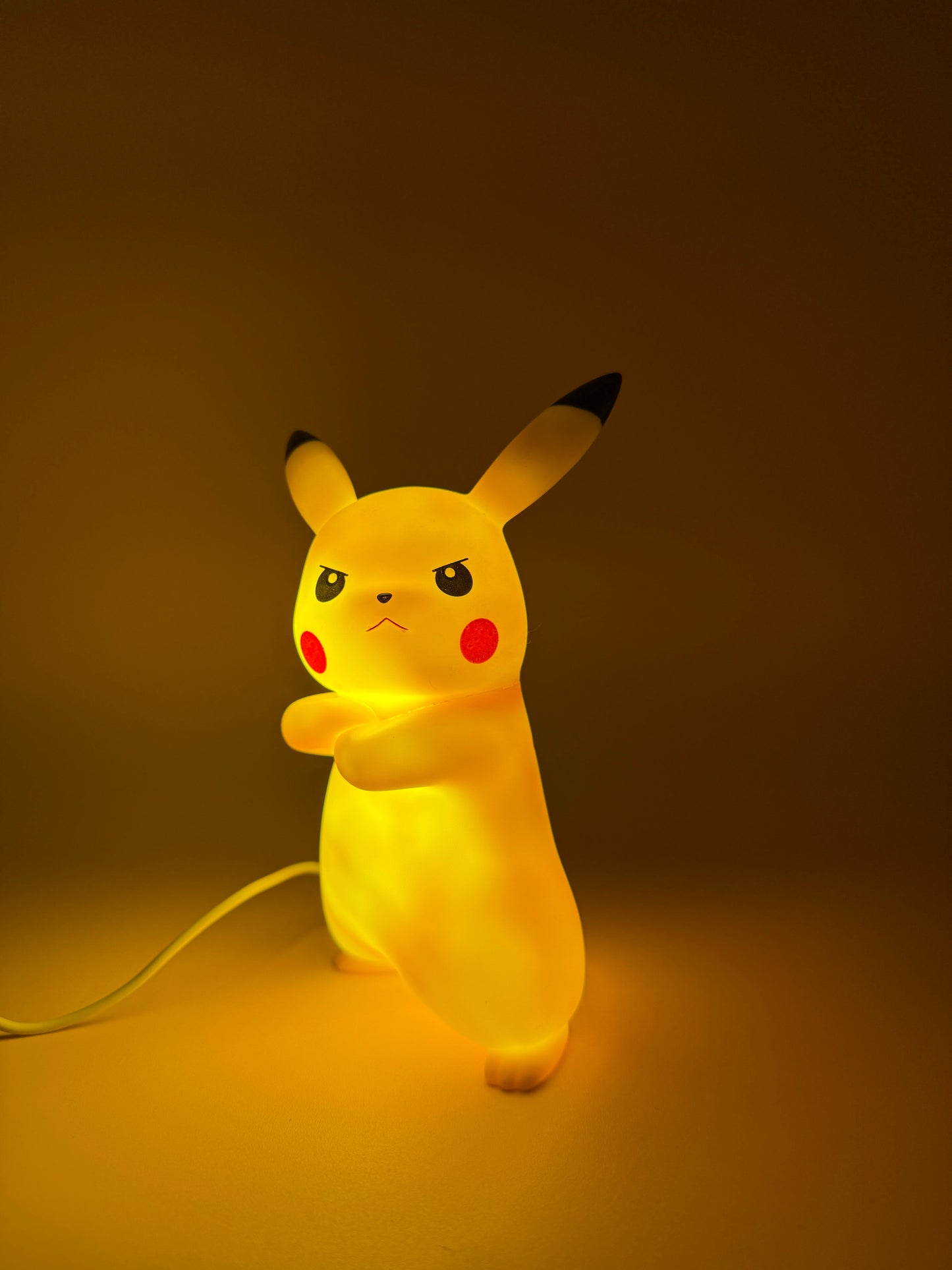 7" Angry Pikachu Statue USB desk lamp illuminated in a dim setting.