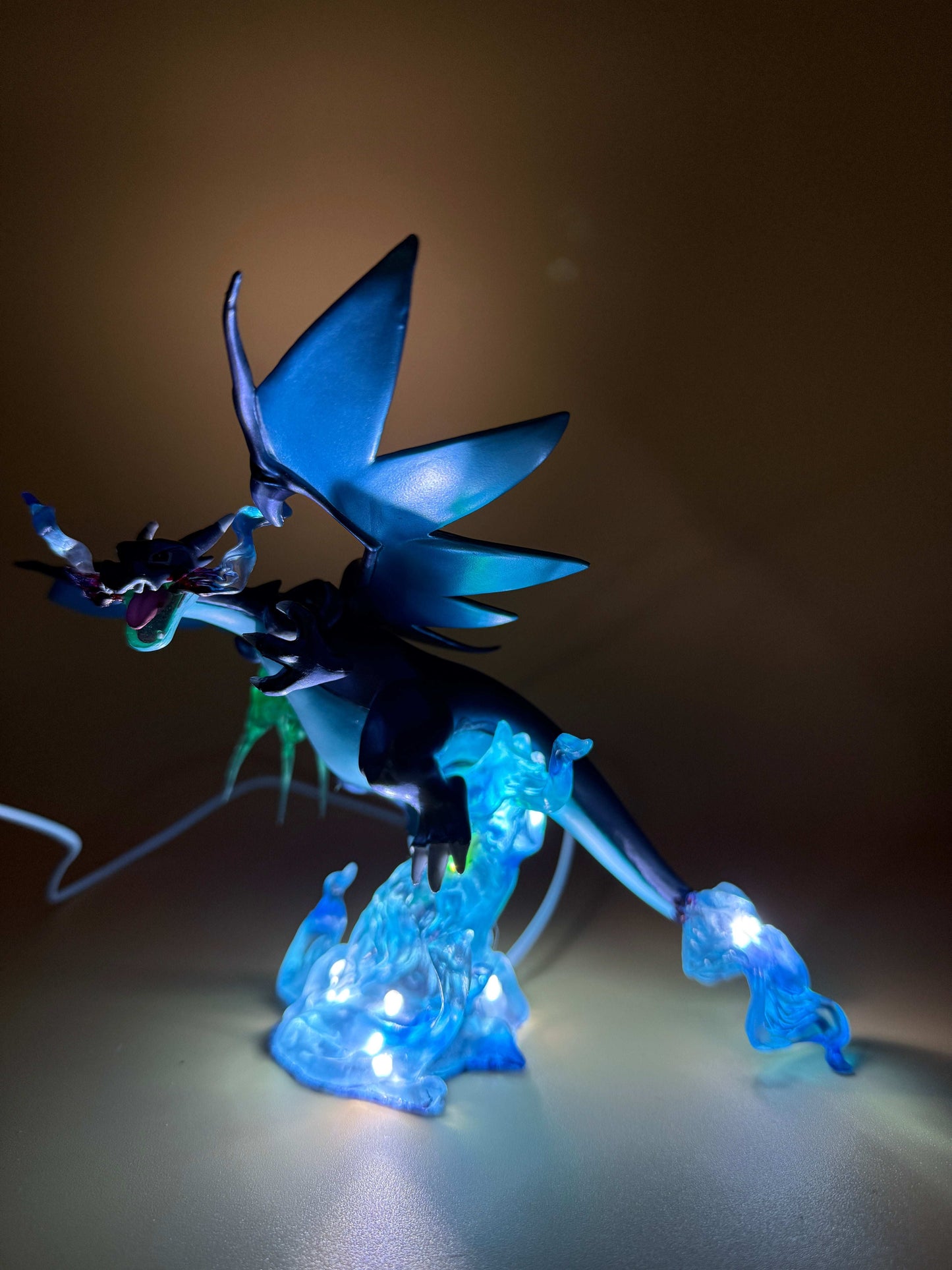 Mega Charizard X statue USB desk lamp with glowing blue accents.