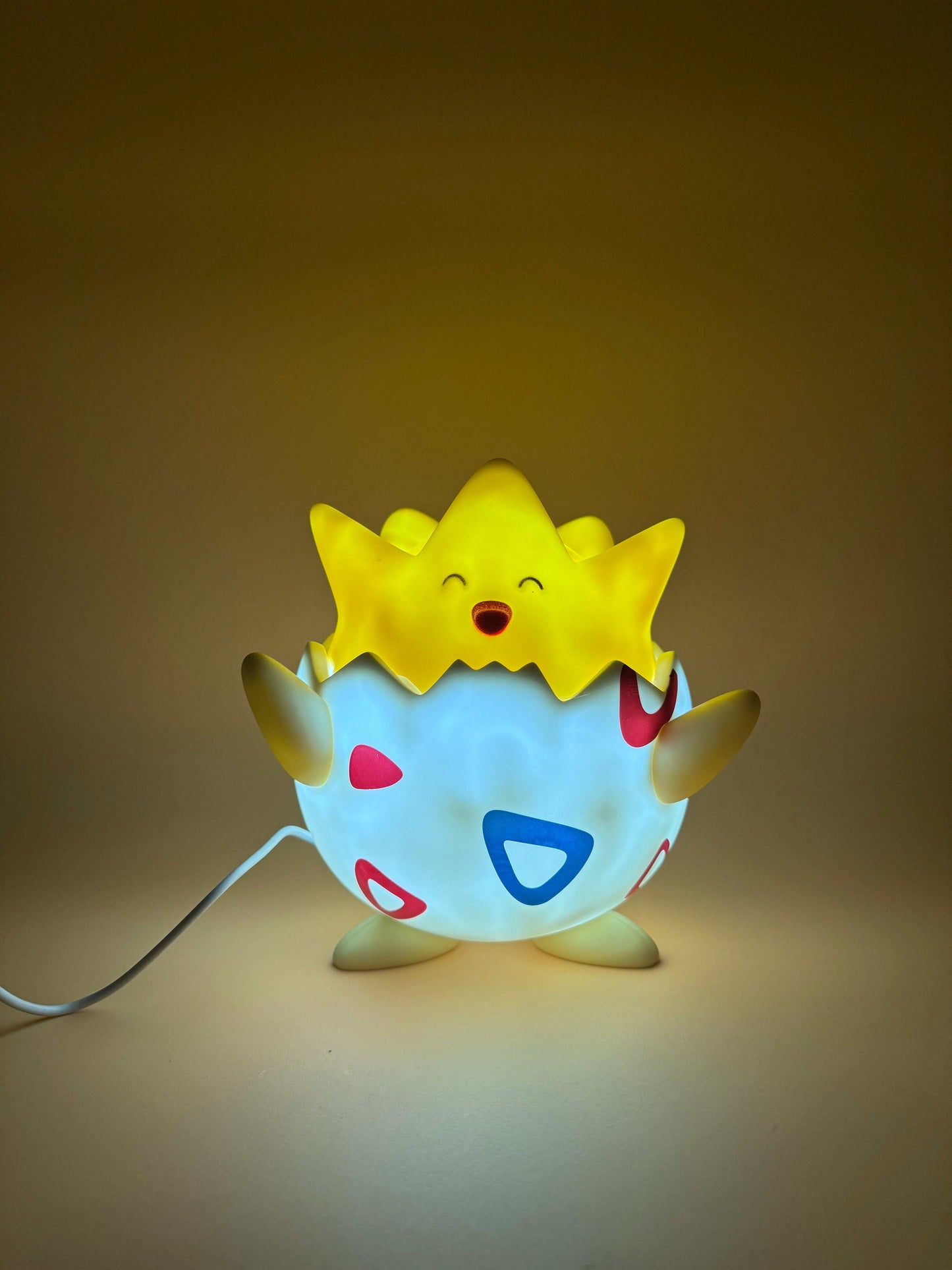Togepi USB desk lamp with built-in cord, glowing softly.