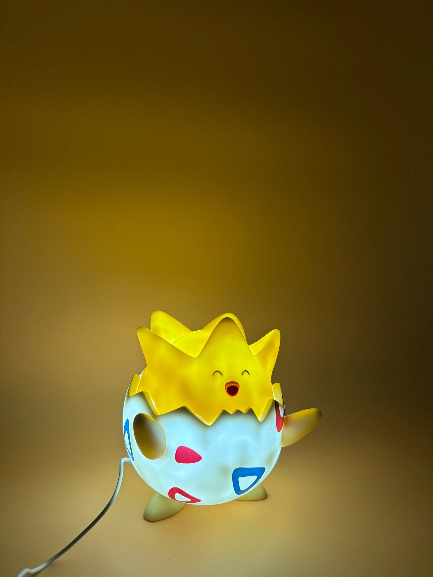 Togepi Desk Lamp with USB cord, 3.5-inch Pokemon statue light, glows warmly.