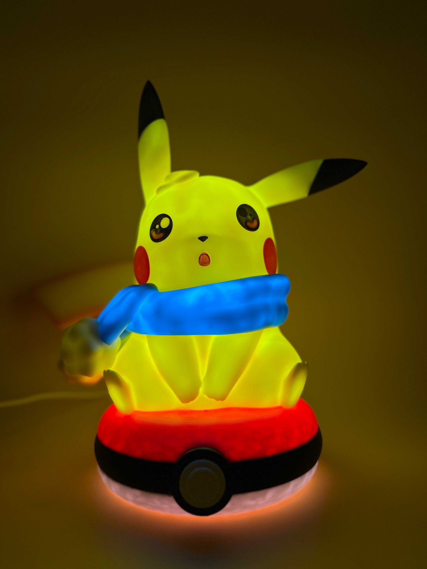 Winter Pikachu Pokeball USB desk lamp with Pikachu in a blue scarf.
