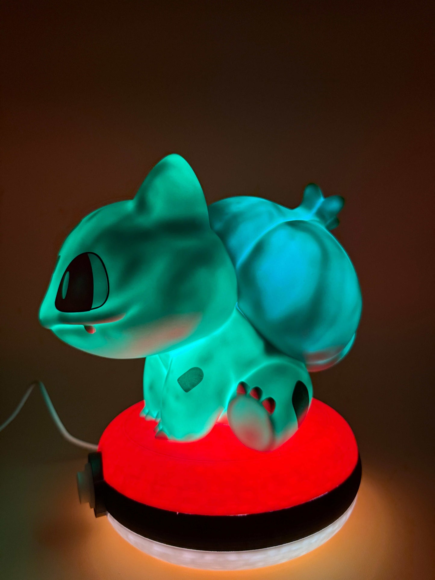Bulbasaur Pokeball Desk Lamp with USB cord, glowing on a red and white Pokeball base.