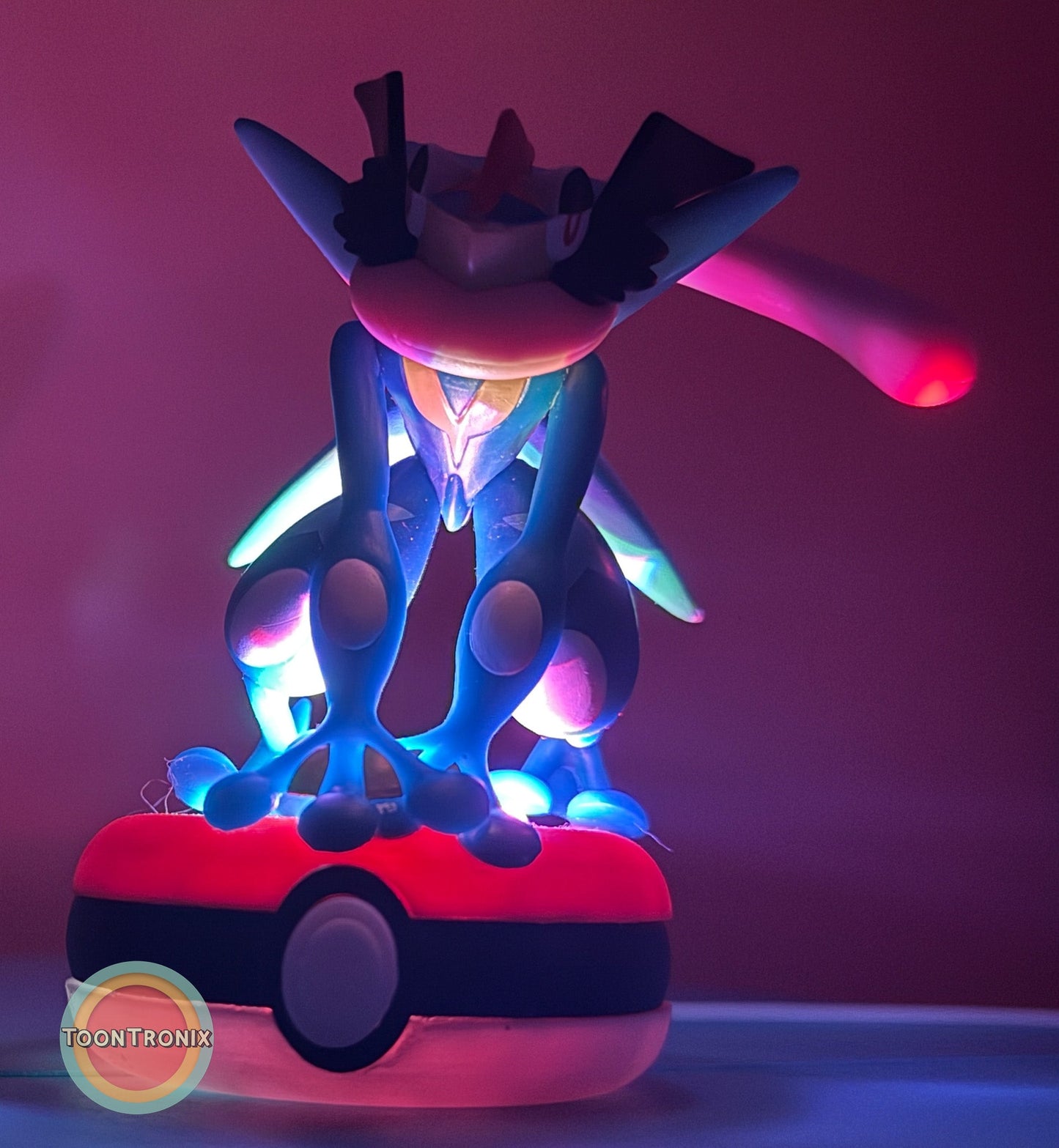 3" Greninja Pokémon USB desk lamp glowing with vibrant blue and pink light on a Poké Ball base