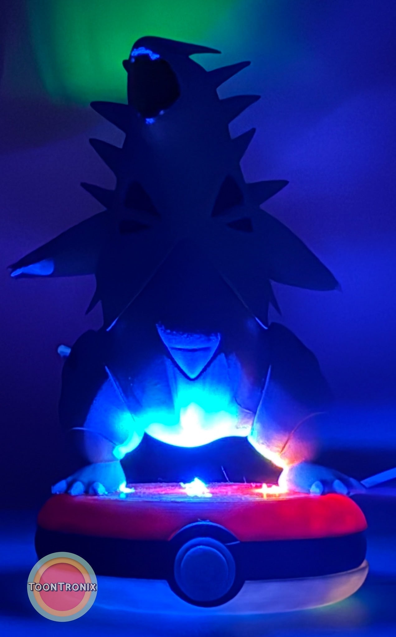 5" Tyranitar Desk Lamp with USB cord glowing blue and red on Pokeball base in dark setting