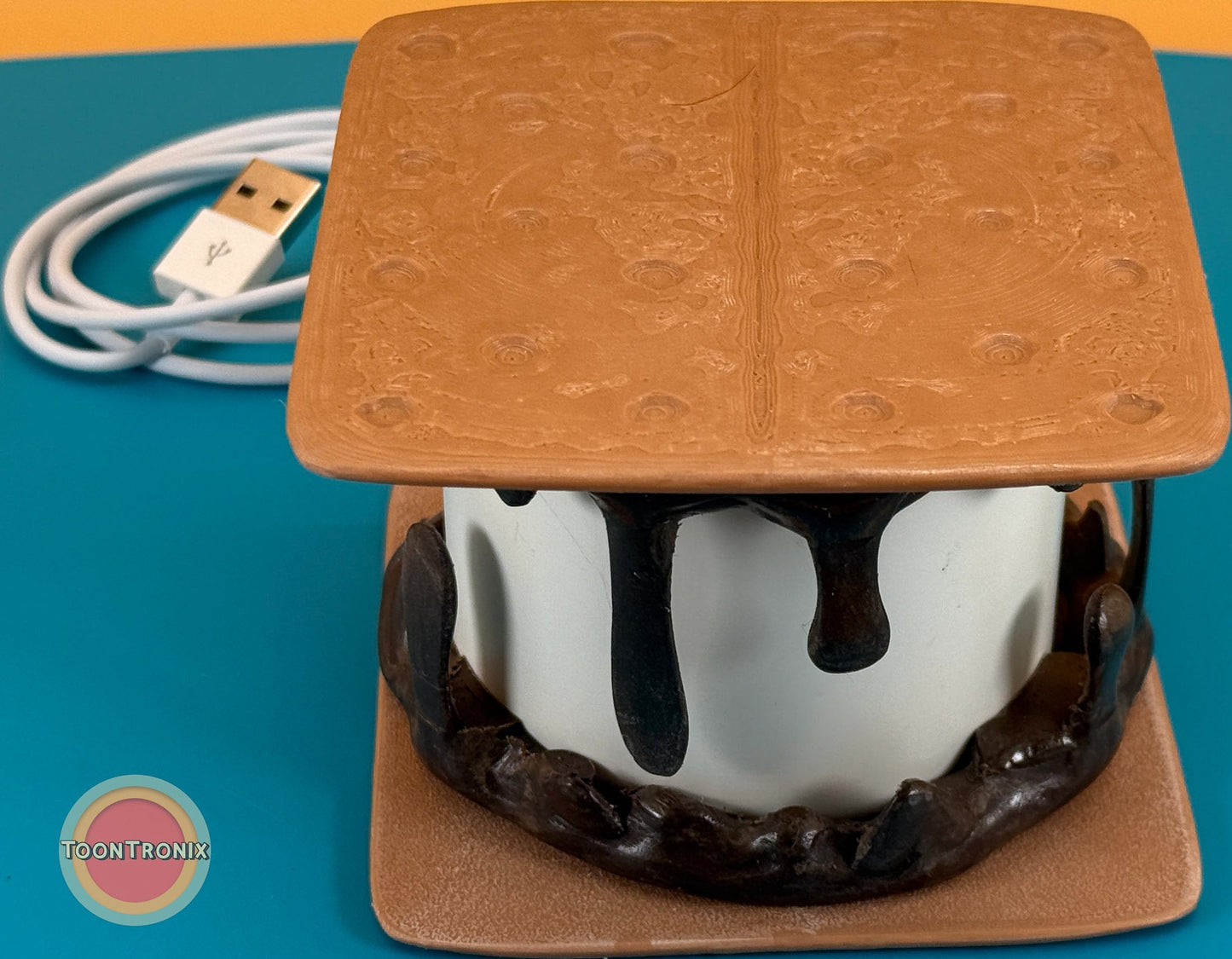 Smores desk lamp with USB cord in retro cartoon style, resembling a toasted marshmallow and chocolate between graham crackers.