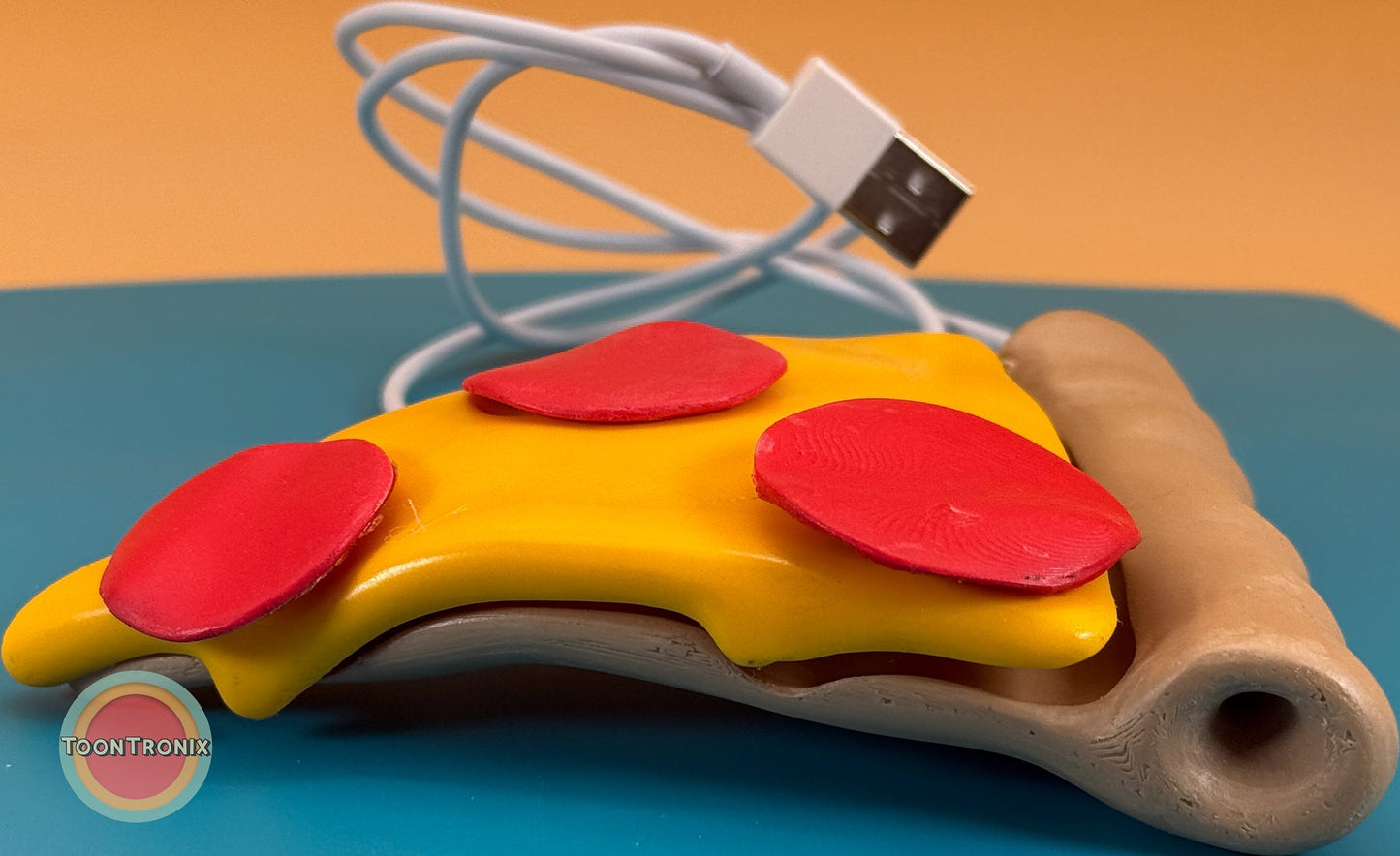 Colorful 6-inch pizza slice desk lamp with USB cord on blue surface