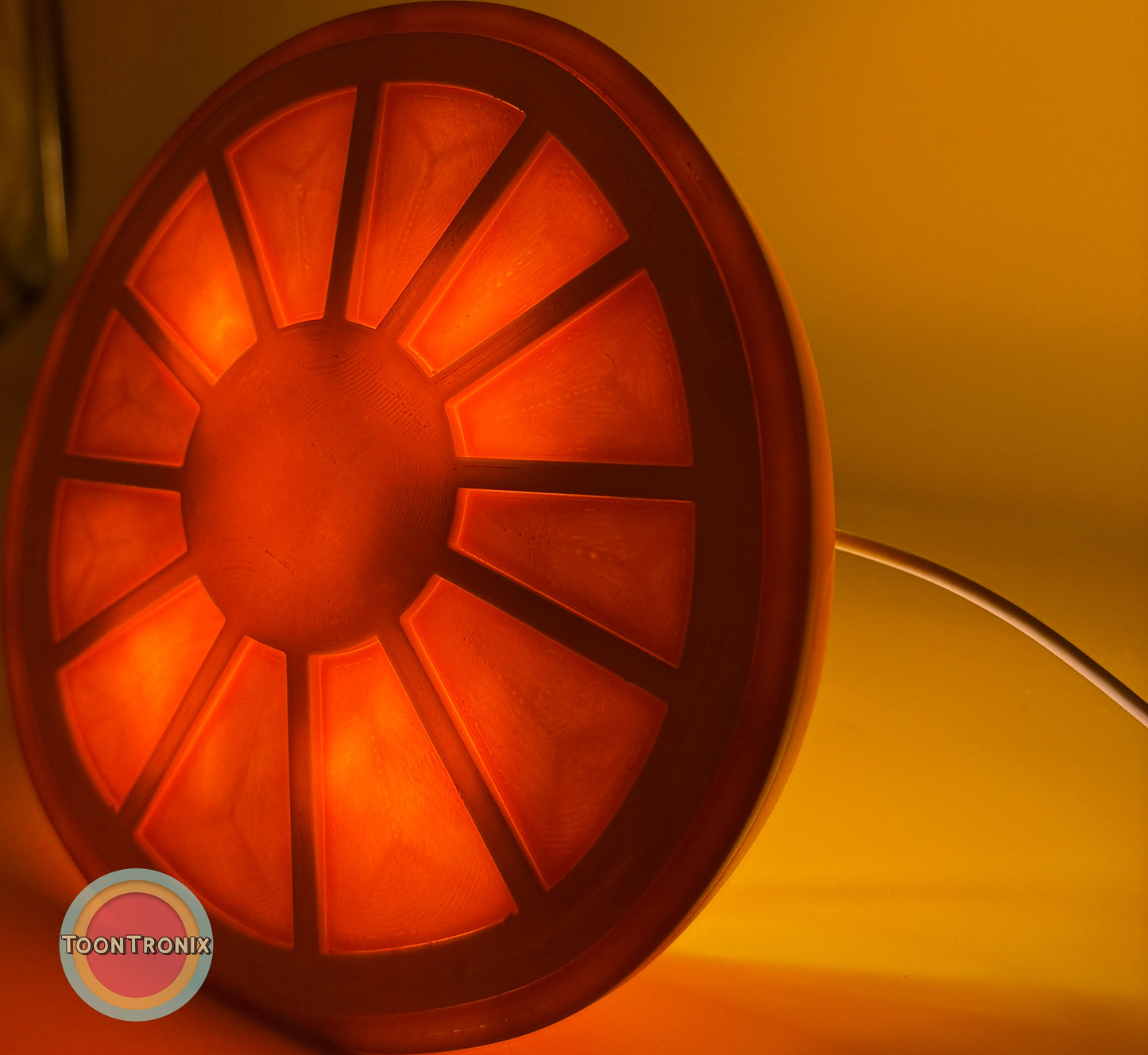 Glowing orange citrus slice shaped desk food lamp with built-in USB cord on warm background