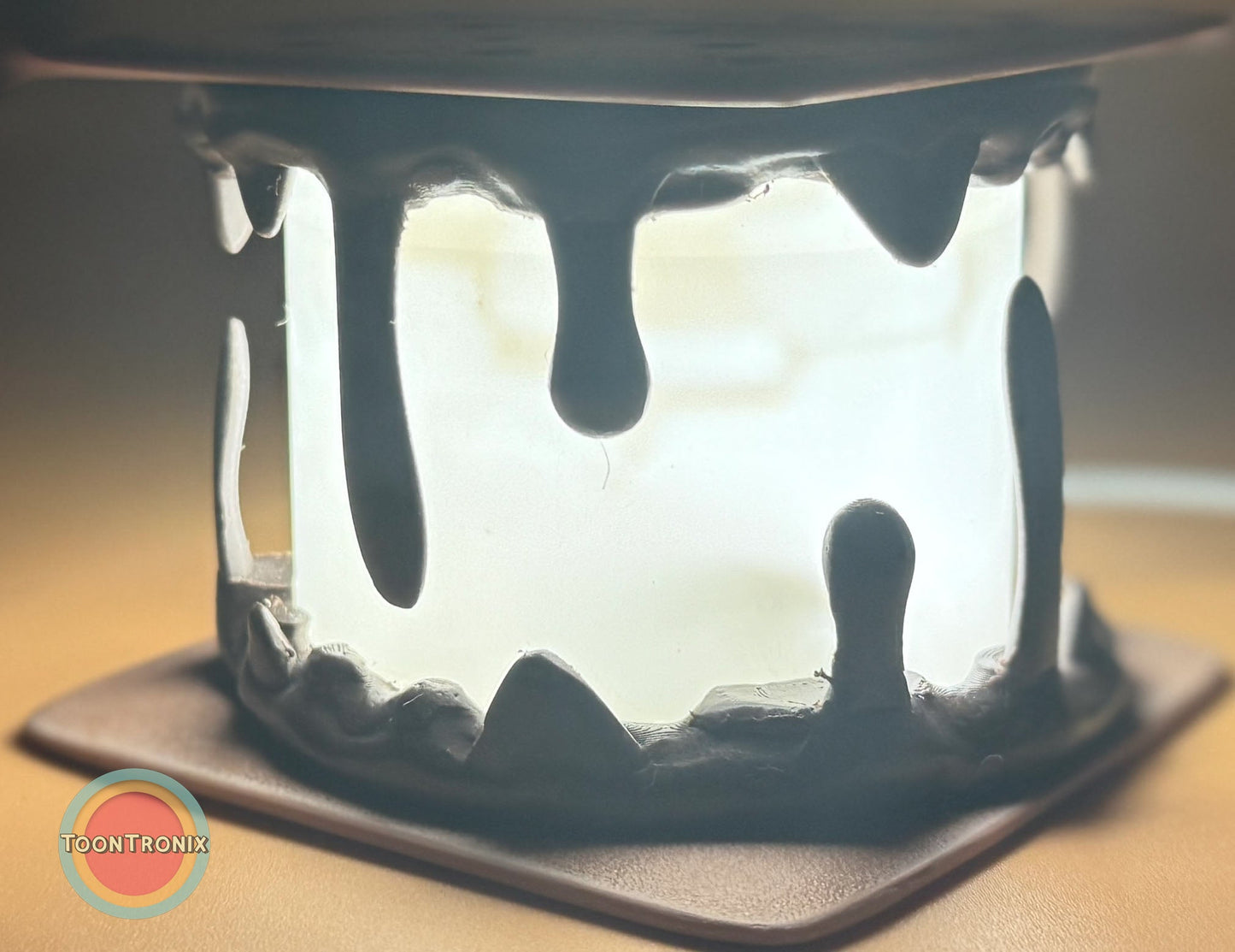 Close-up of a glowing Smores Desk Lamp with dripping marshmallow design on a square base