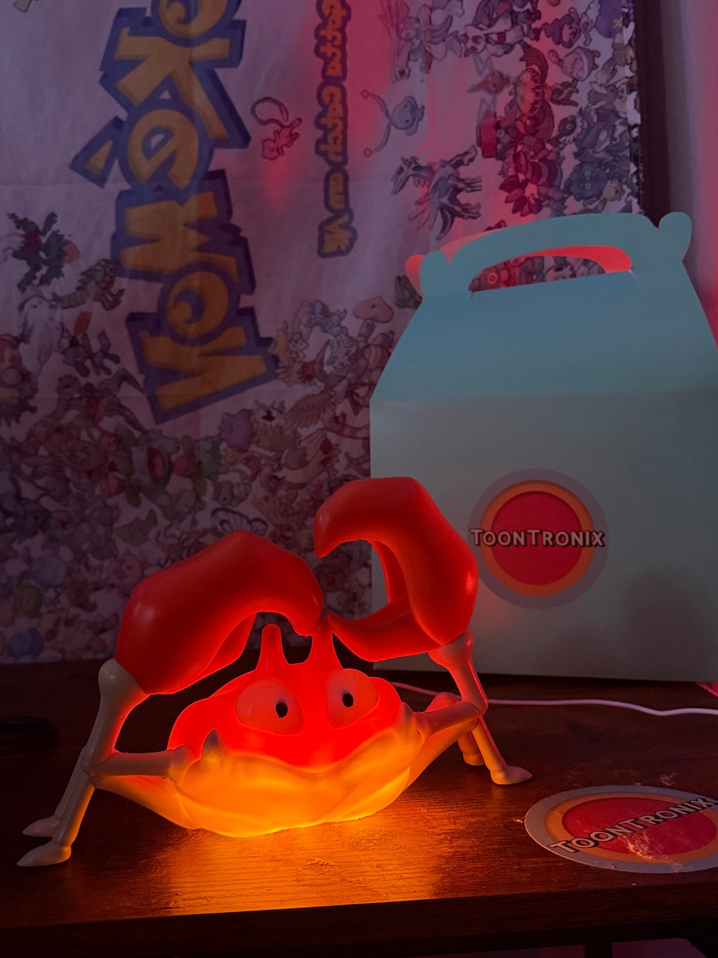 6" Krabby desk lamp glowing red with USB cord and wood-like finish on a wooden surface