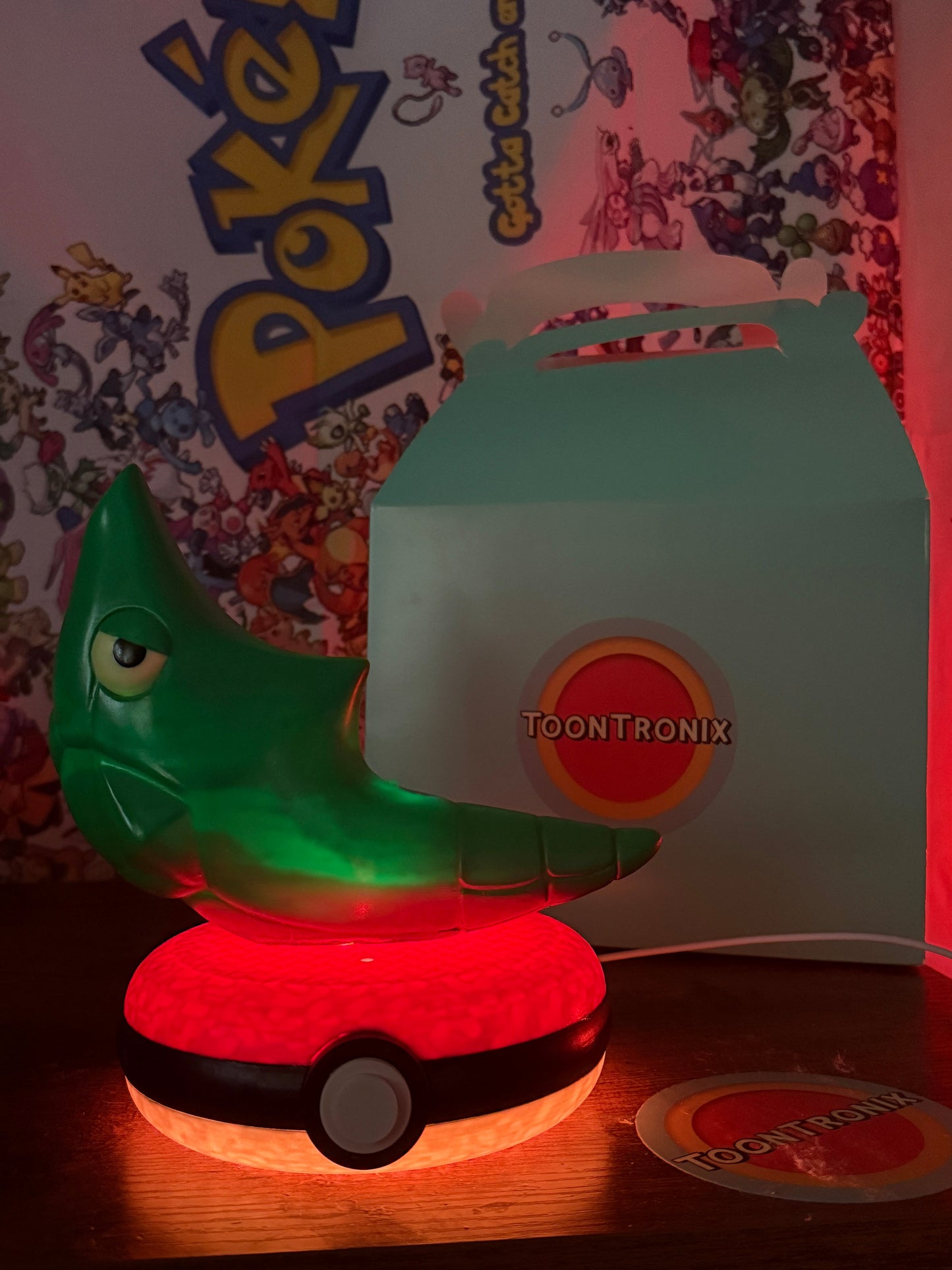 8 inch Metapod Pokemon statue desk lamp with USB cord and wood-like finish on a glowing Pokeball base
