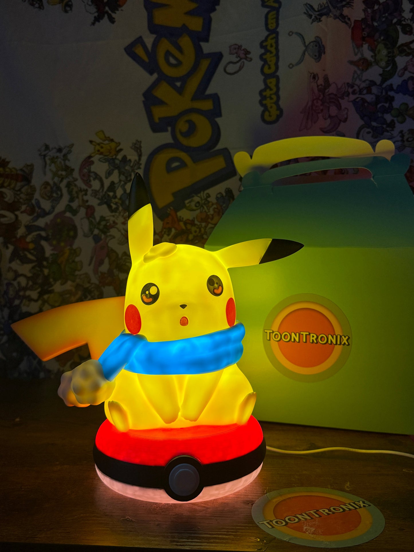 10.5-inch Winter Pikachu Pokeball LED USB desk lamp glowing in warm yellow with blue scarf and red base.
