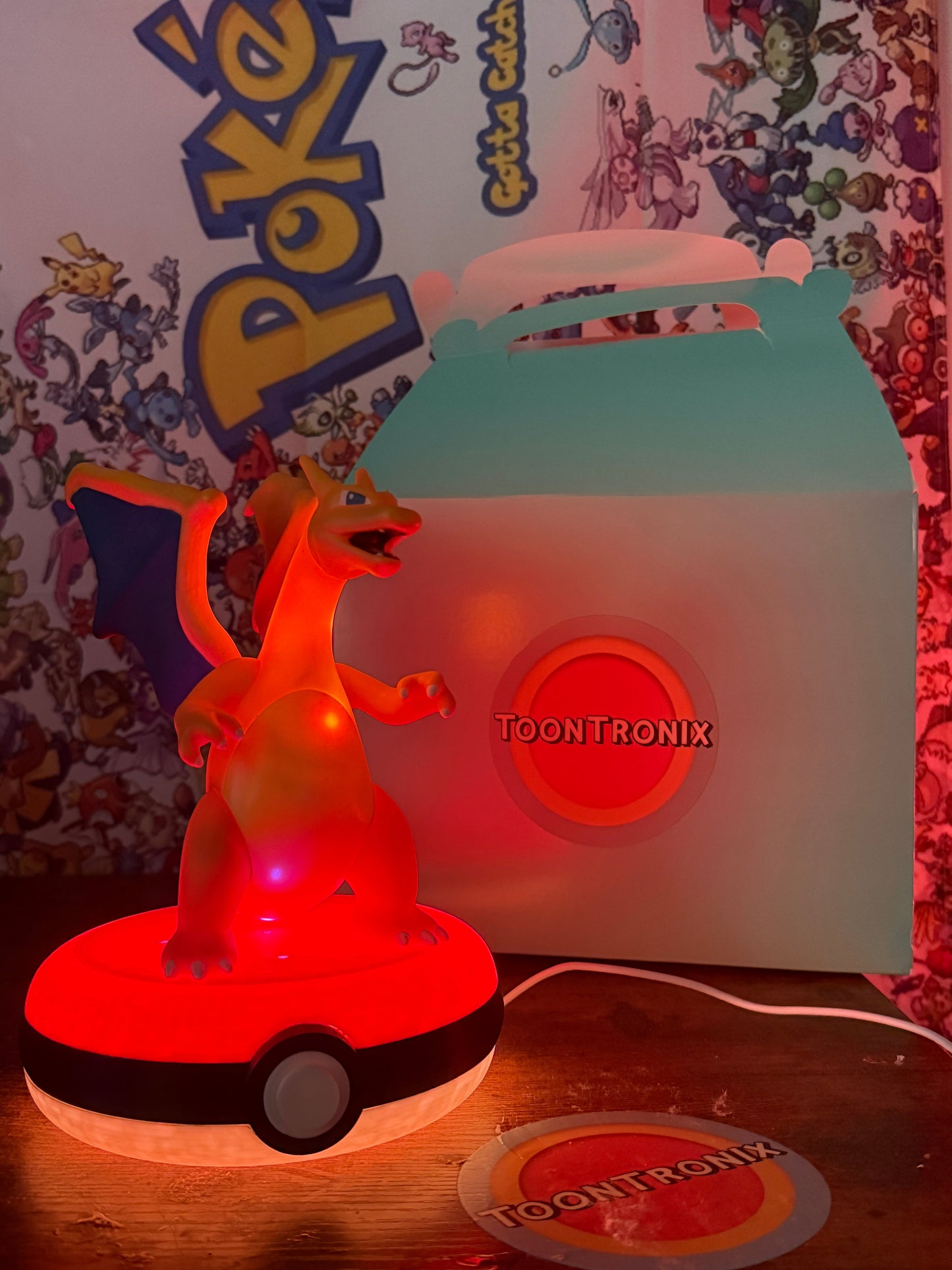 8-inch Charizard Pokeball desk lamp with LED light and built-in USB cord on wooden surface with Pokémon backdrop