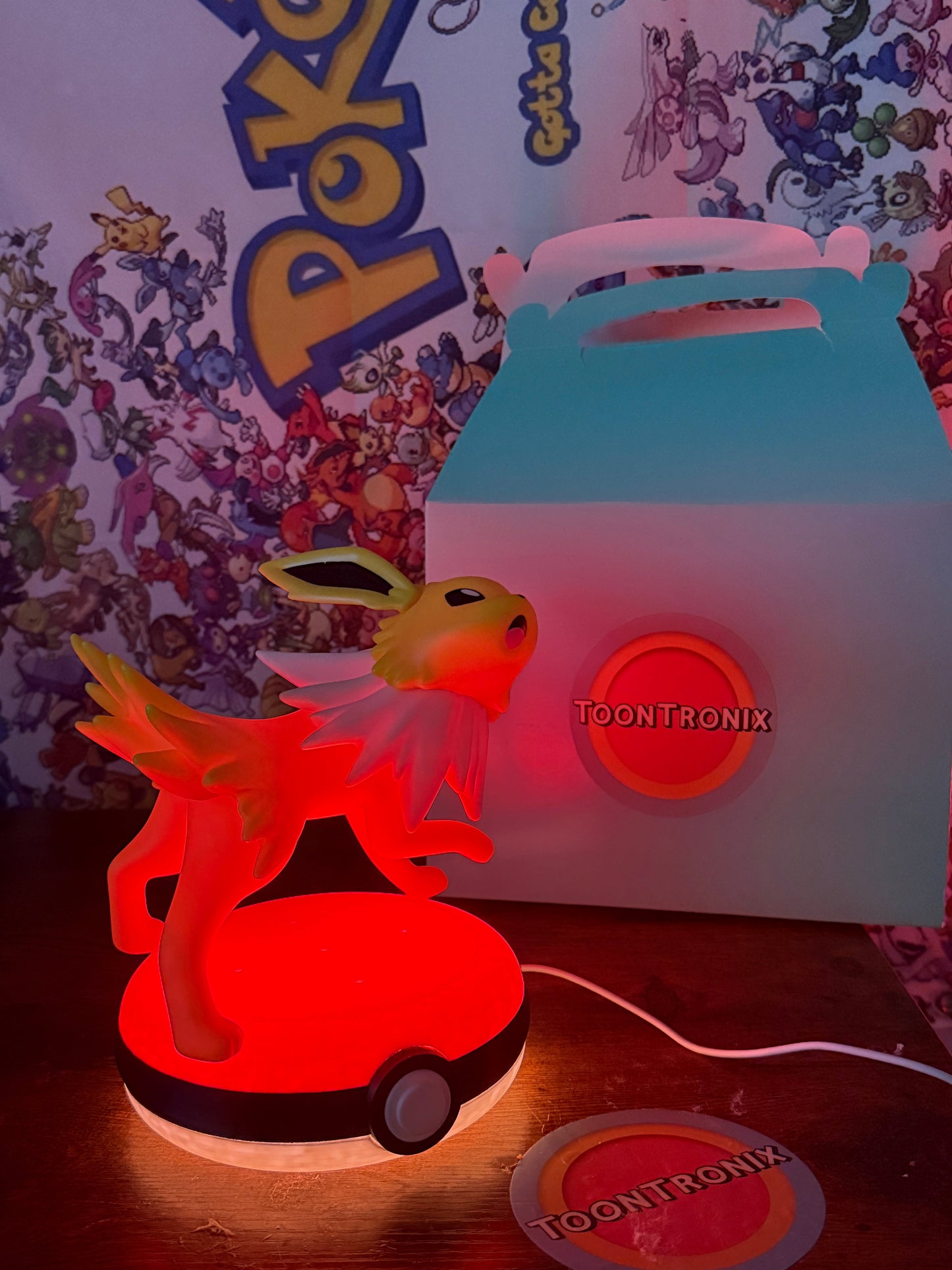 Jolteon Pokeball desk lamp figure with LED light and built-in USB cord on glowing red base