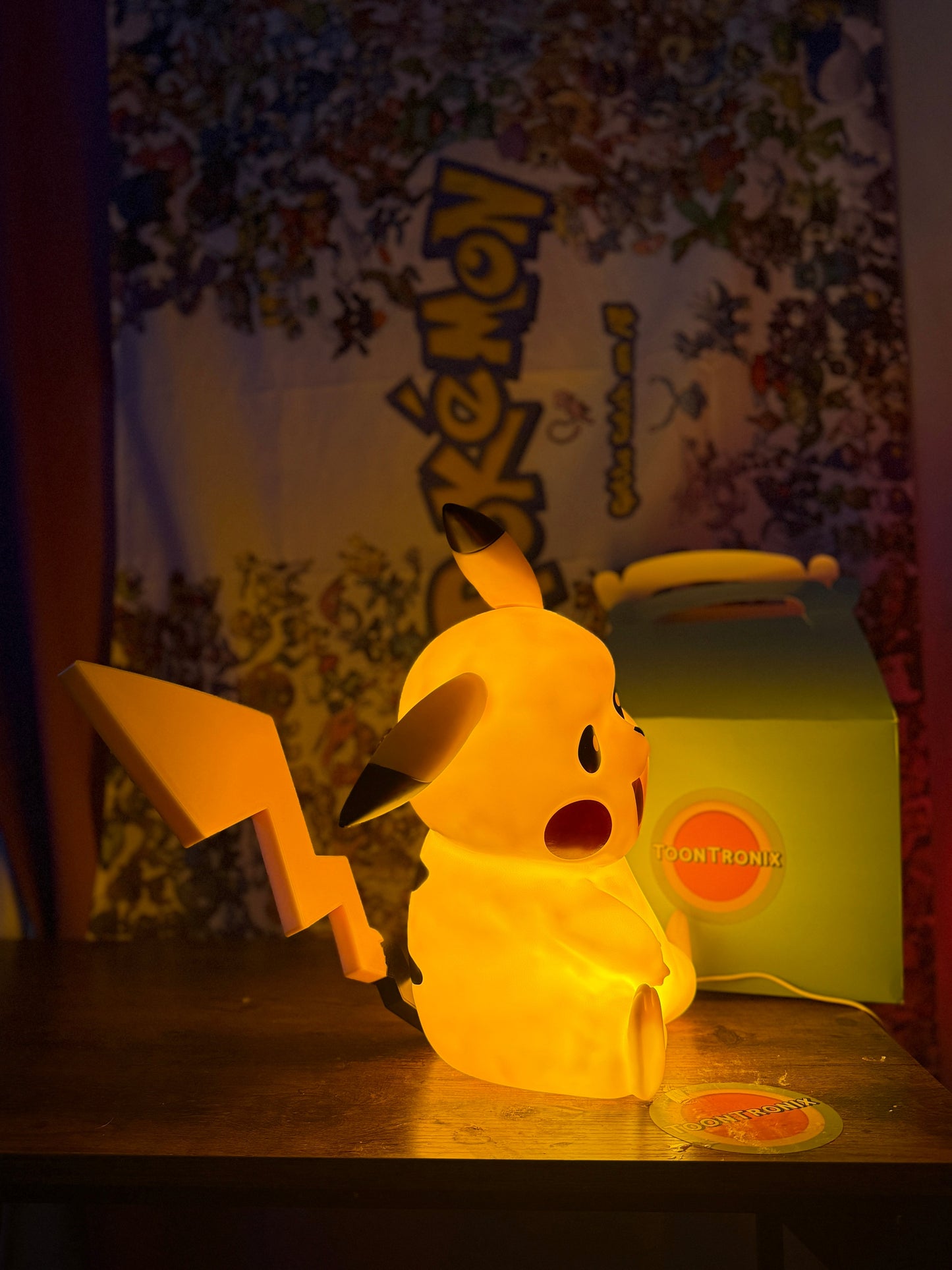 13" Pikachu large statue LED USB desk lamp glowing warmly on wooden surface with Pokemon backdrop