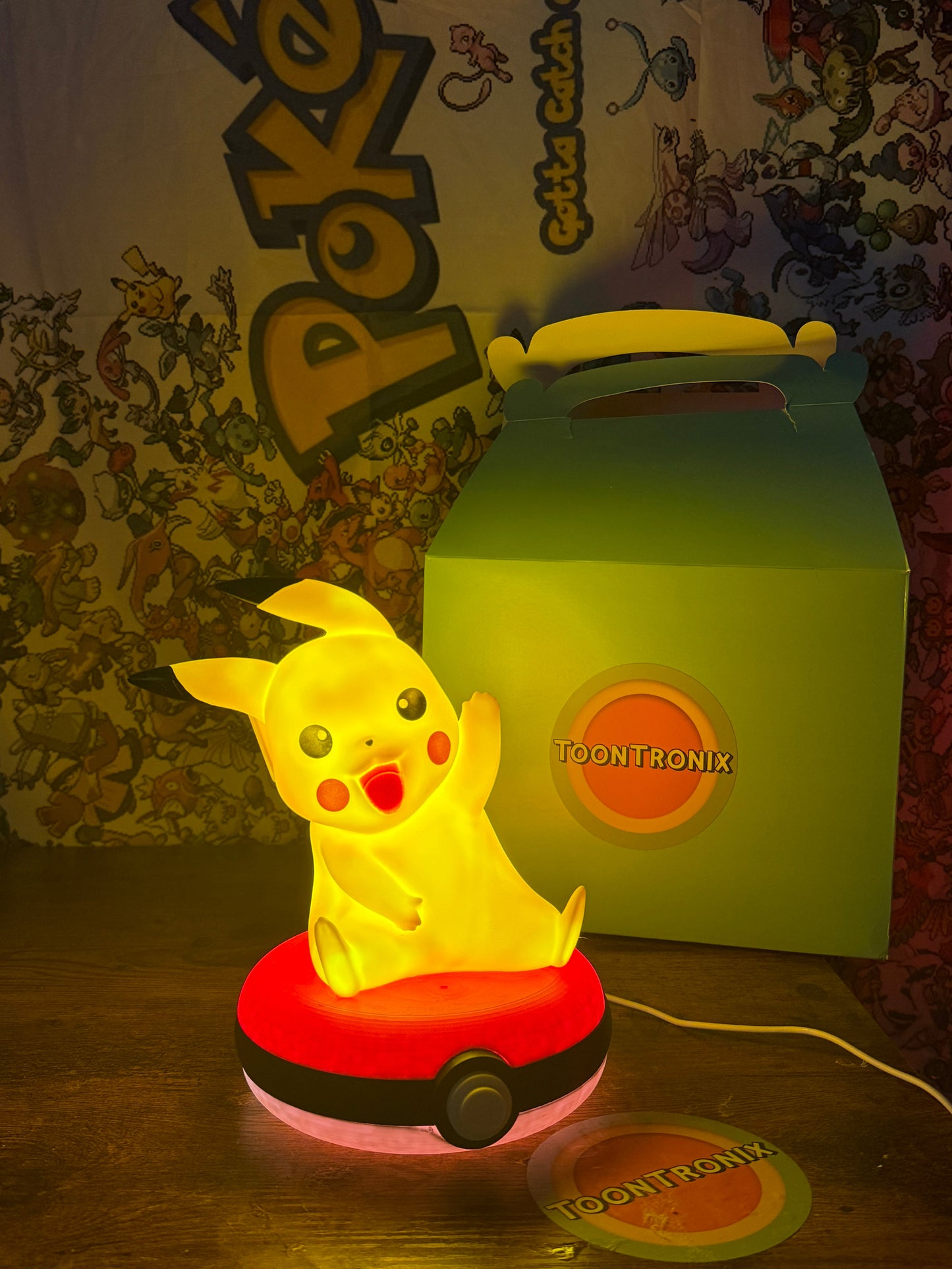 8" Pikachu Pokeball desk lamp LED light with USB cord on wooden surface and Toontronix box in background