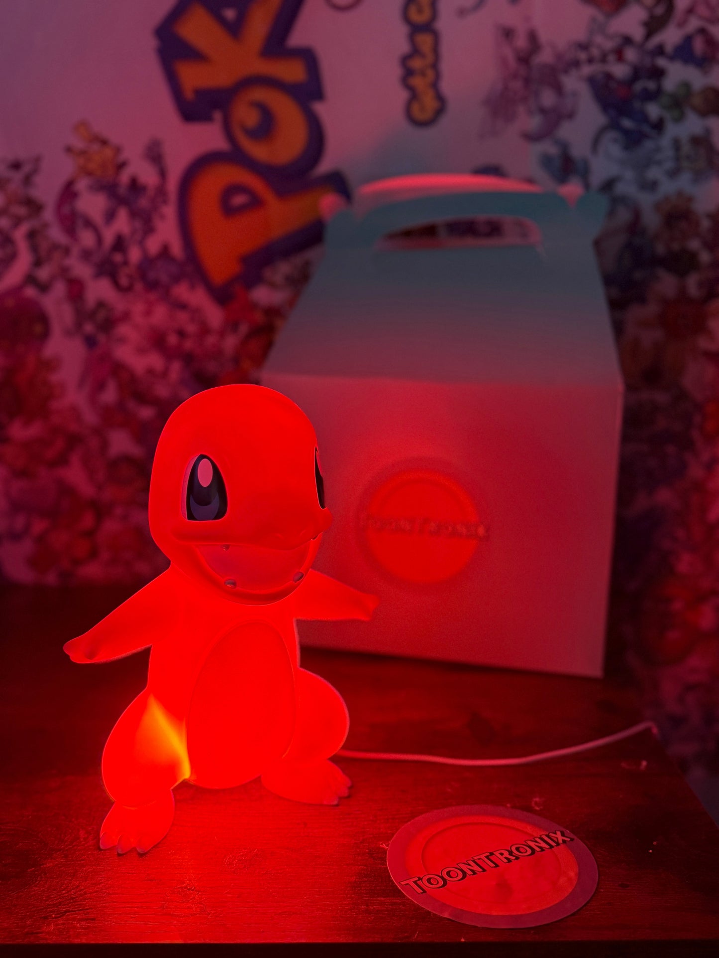 9" Charmander Statue USB desk lamp glowing red on wooden surface with Pokemon backdrop