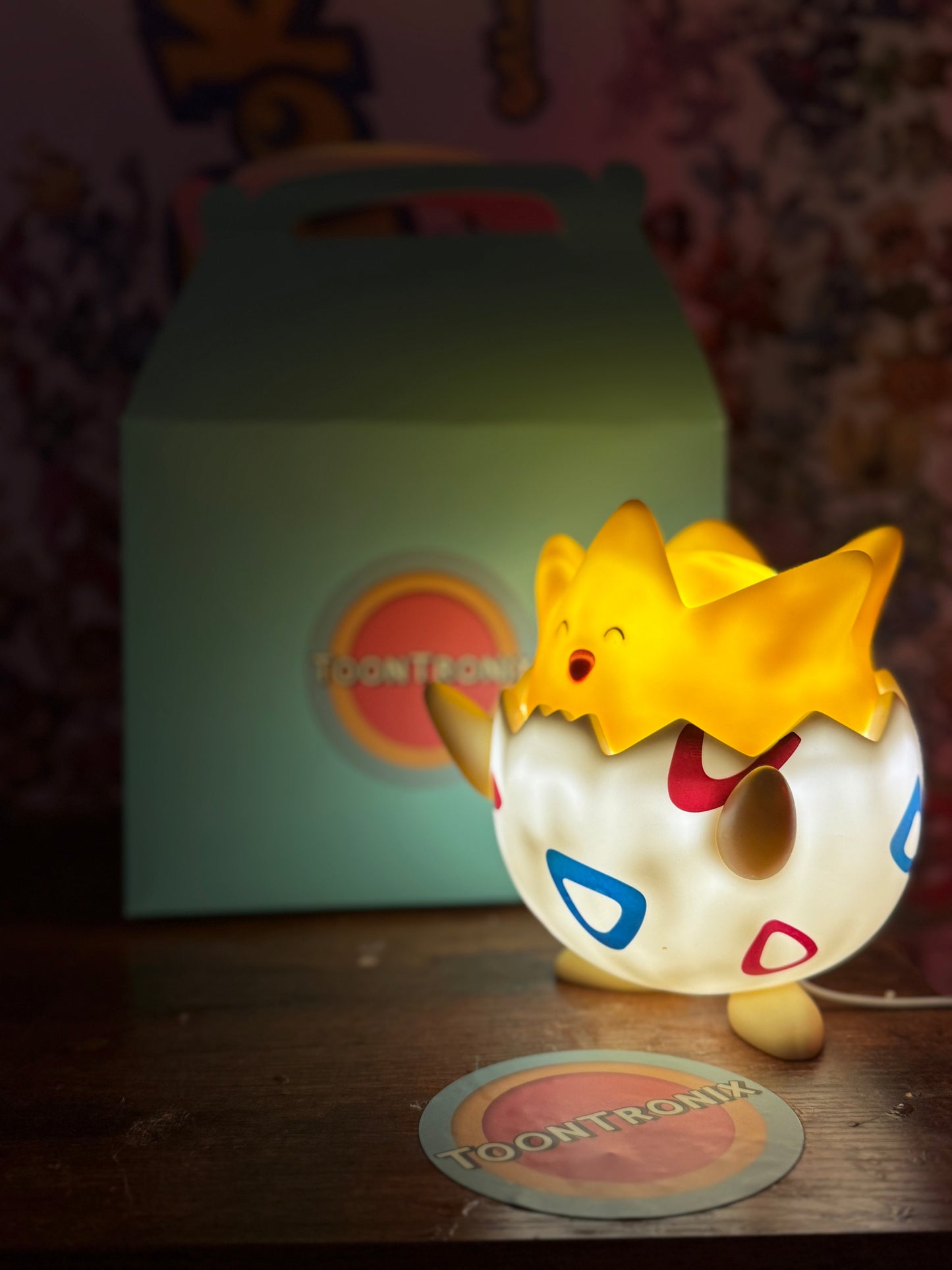 7" Togepi Statue USB LED desk lamp glowing with soft yellow light on wooden surface with Toontronix box in background