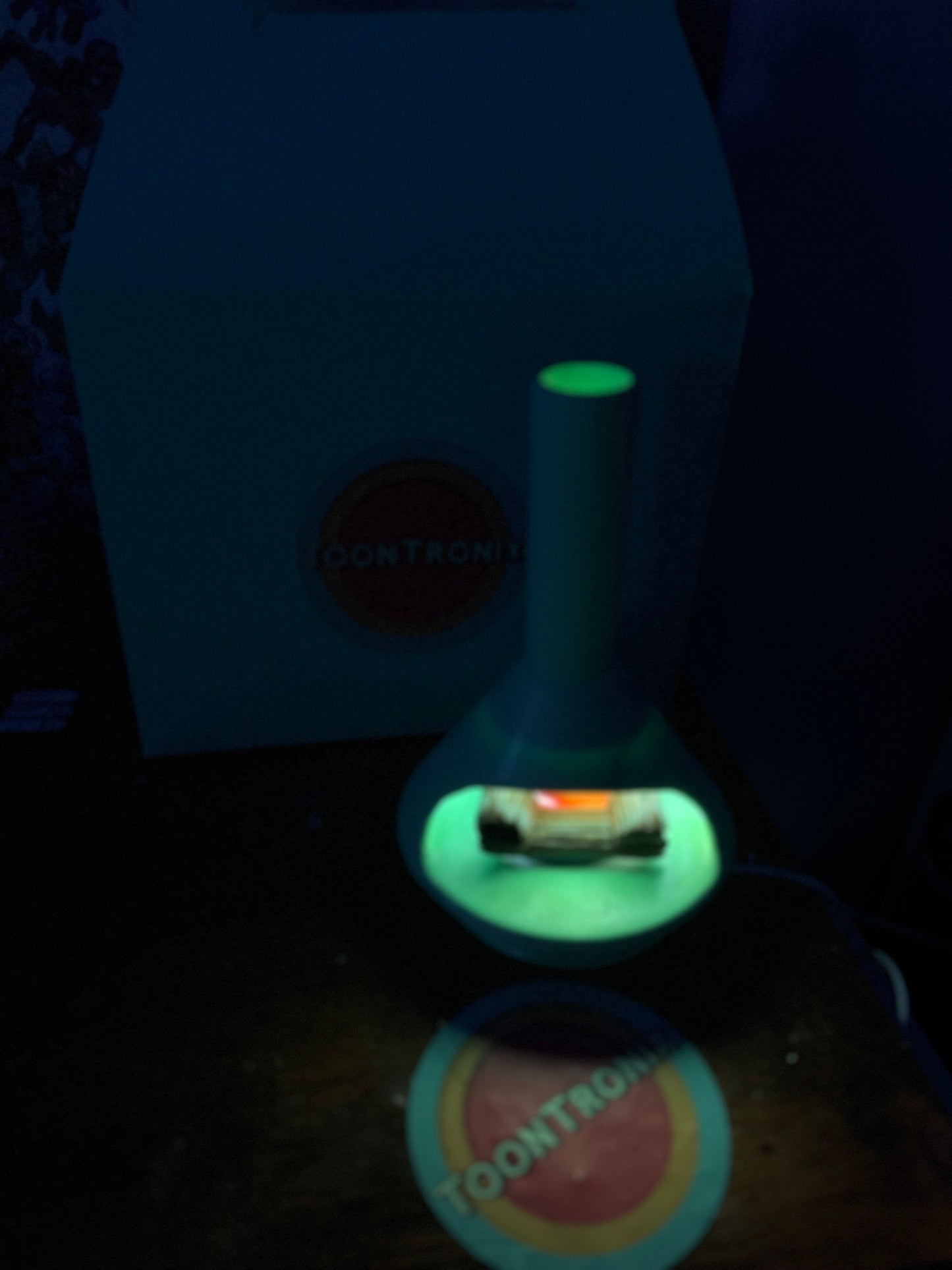 Retro fireplace desk lamp glowing green with USB power on a dark desk.