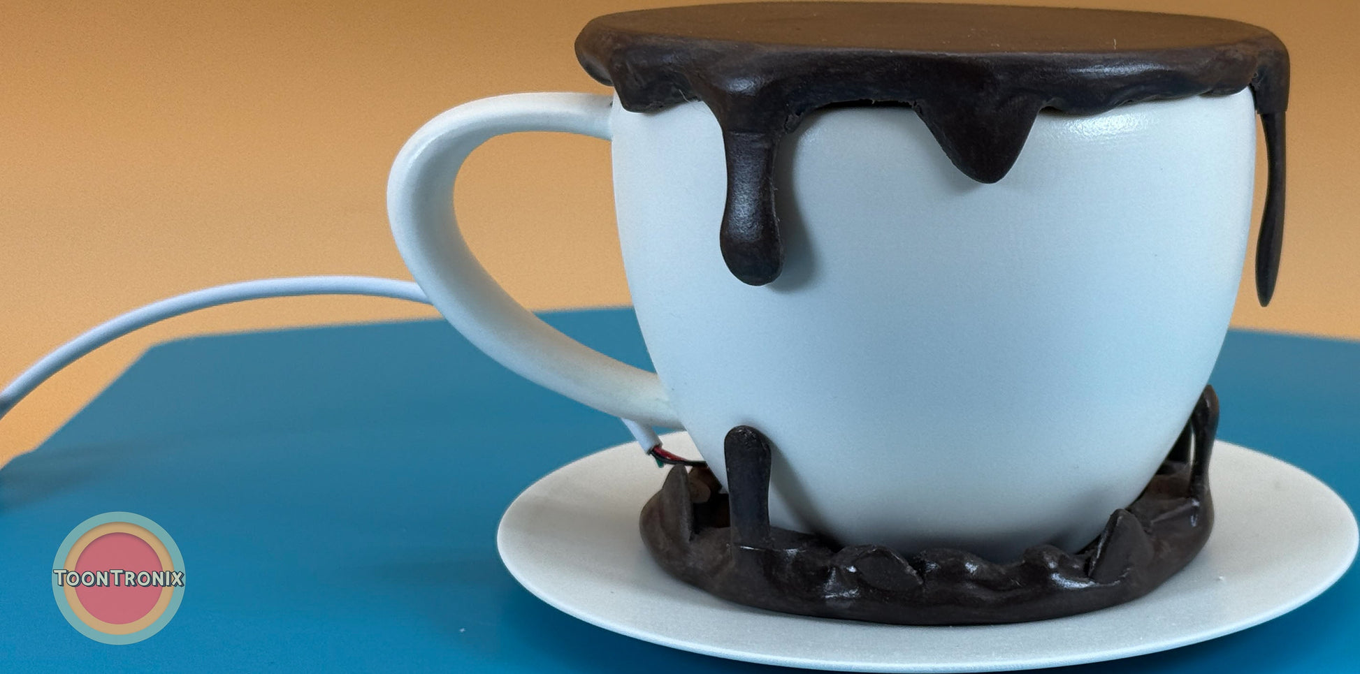 6" or 9" coffee desk lamp shaped like a white cup with black dripping detail and a built-in USB cord on a blue surface