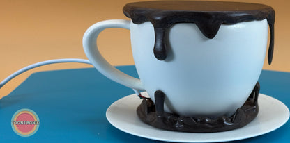 6" or 9" coffee desk lamp shaped like a white cup with black dripping detail and a built-in USB cord on a blue surface