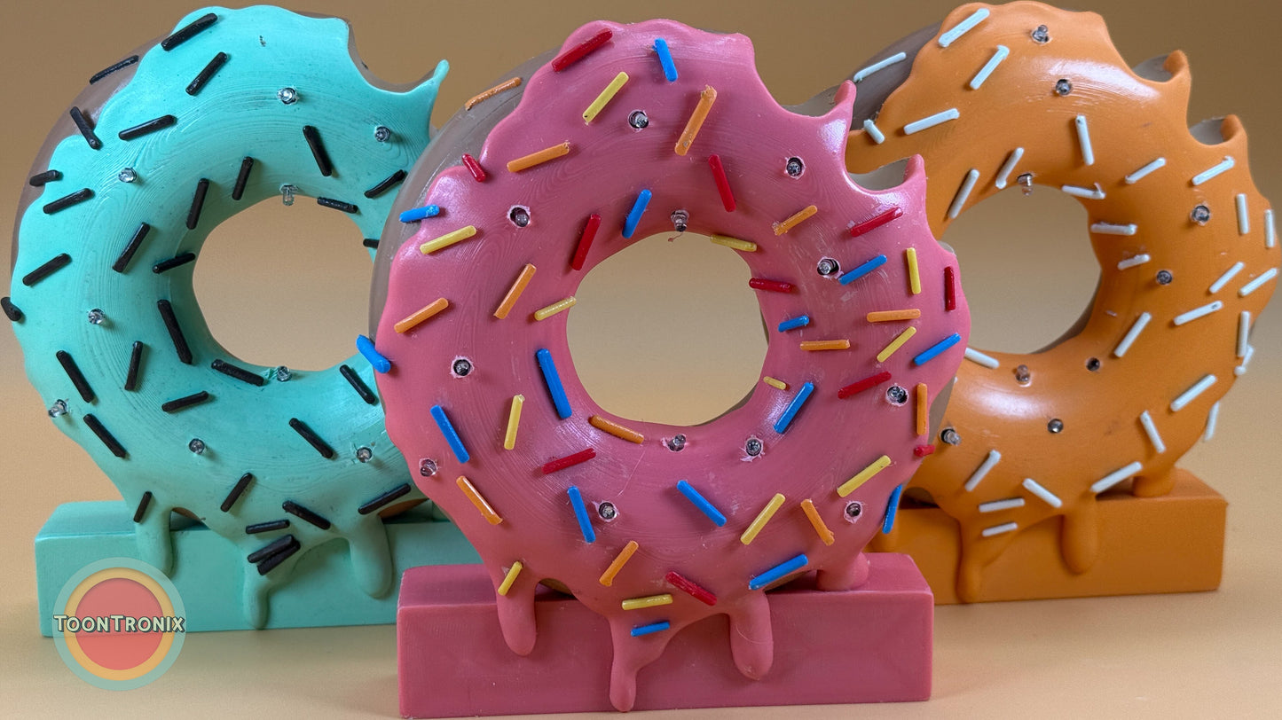 Colorful 6" or 9" donut-shaped desk lamps with sprinkles and USB power cord in blue, pink, and orange designs