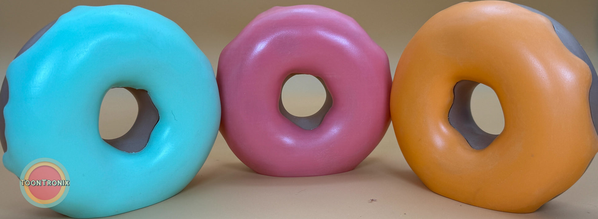 Colorful retro-style donut desk lamps in blue, pink, and orange from the Atomic Series with vibrant cartoon palette and USB power cord.