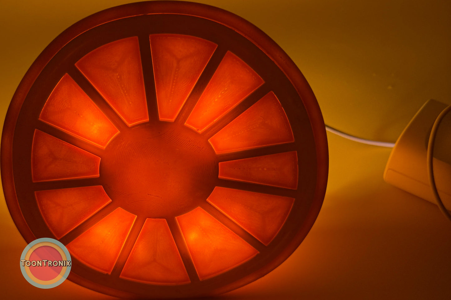 Glowing orange desk food lamp shaped like a sliced fruit with USB cord attached