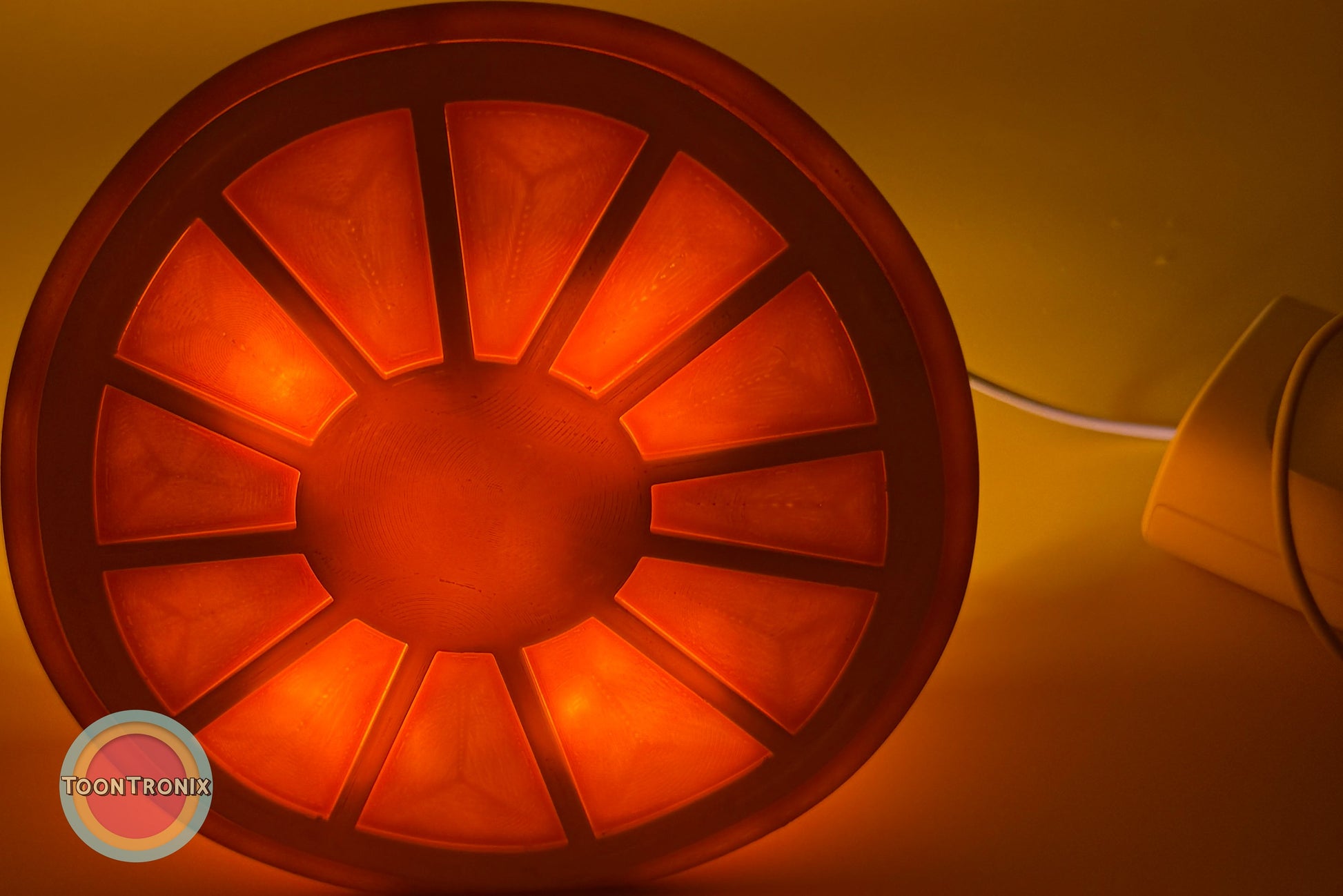 Glowing orange desk food lamp shaped like a sliced fruit with USB cord attached