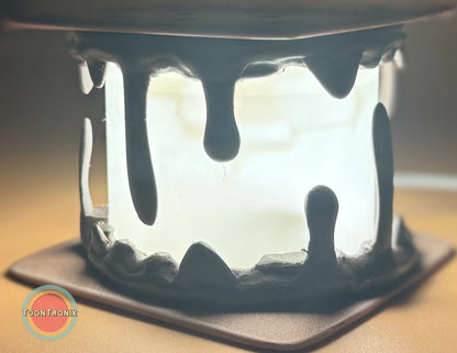 Close-up of a glowing Smores Desk Lamp with dripping marshmallow design on a square base