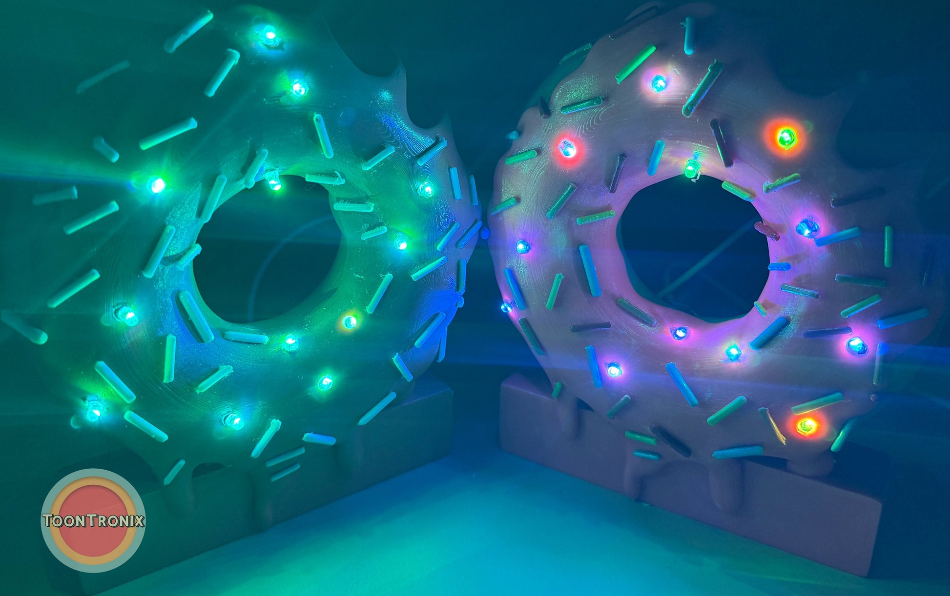 Colorful 6" and 9" donut-shaped desk lamps with sprinkles and glowing LED lights on a blue background