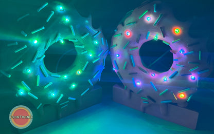 Colorful 6" and 9" donut-shaped desk lamps with sprinkles and glowing LED lights on a blue background
