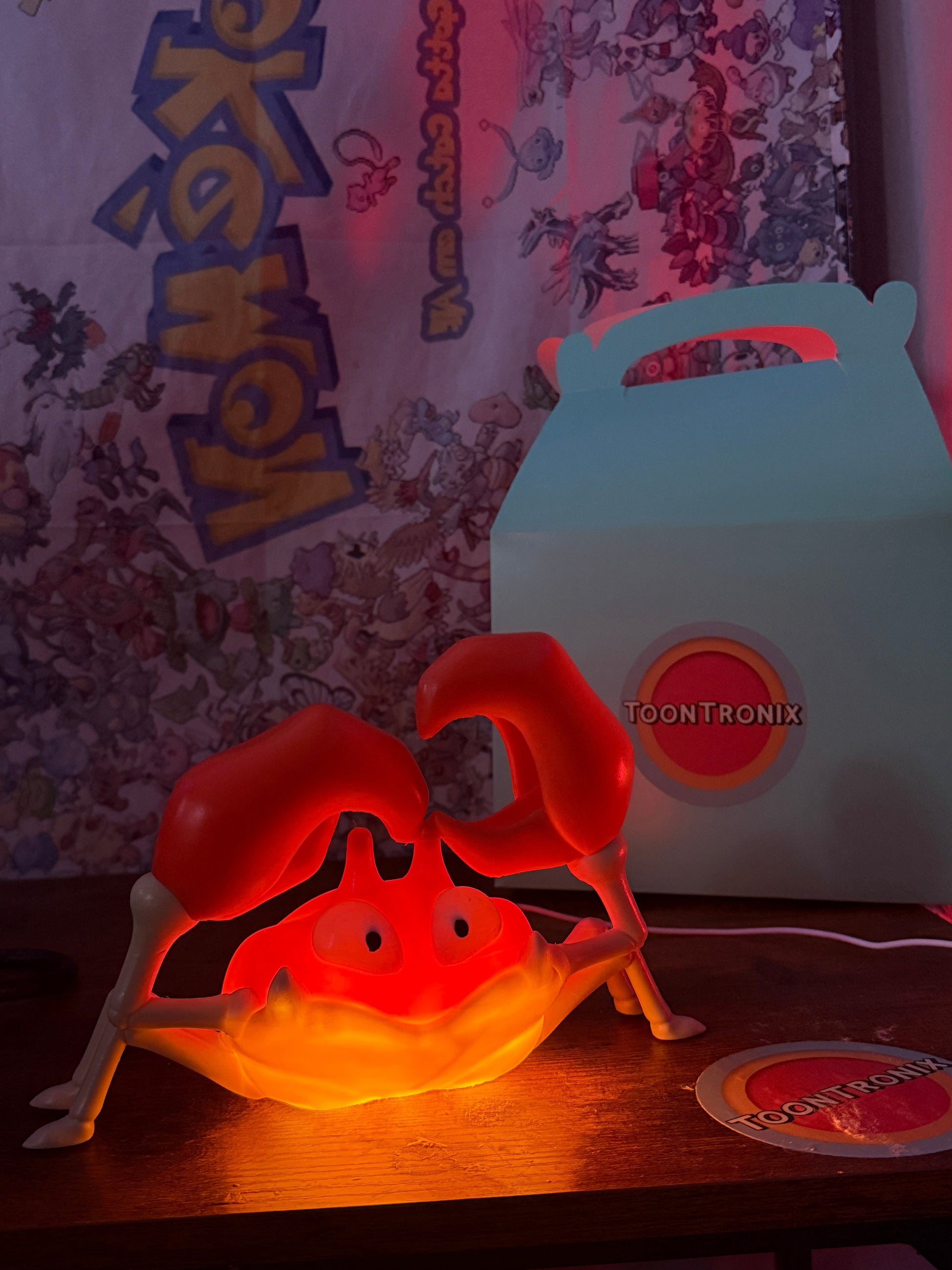 6" Krabby desk lamp glowing red with USB cord and wood-like finish on a wooden surface