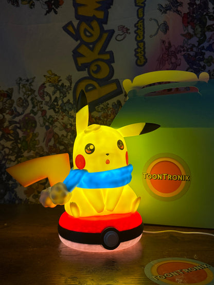 Winter Pikachu Pokeball USB LED desk lamp figure with glowing yellow Pikachu wearing blue scarf on red and white Pokeball base