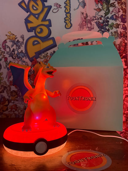 8-inch Charizard Pokeball desk lamp with LED light and built-in USB cord on wooden surface with Pokémon backdrop