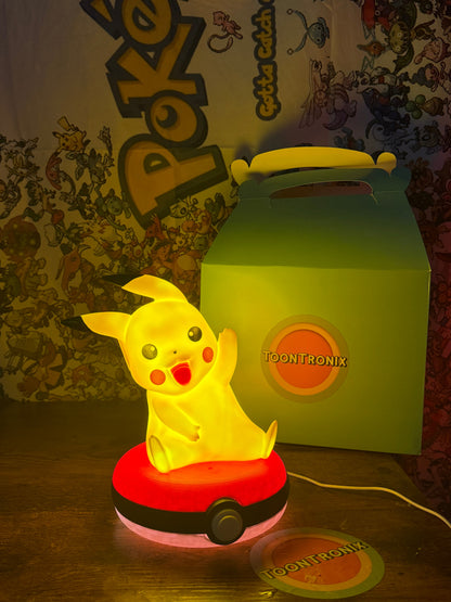 8" Pikachu Pokeball desk lamp LED light with USB cord on wooden surface and Toontronix box in background