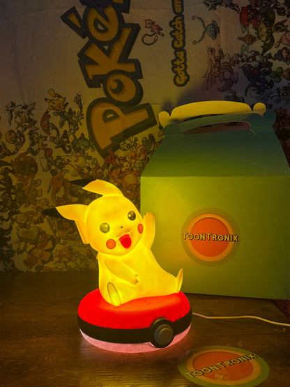 Glowing Pikachu figure sitting on a Pokeball base USB desk lamp with warm yellow light and Pokemon-themed background.