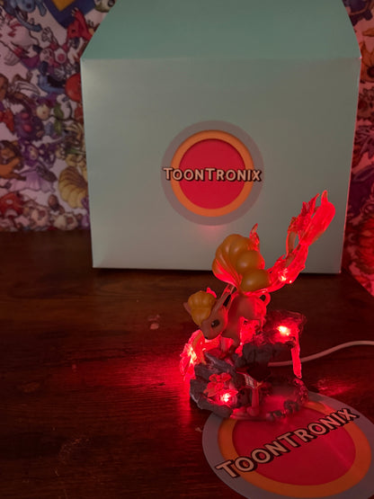 5" Vulpix statue LED desk lamp with USB cord glowing red on wooden surface