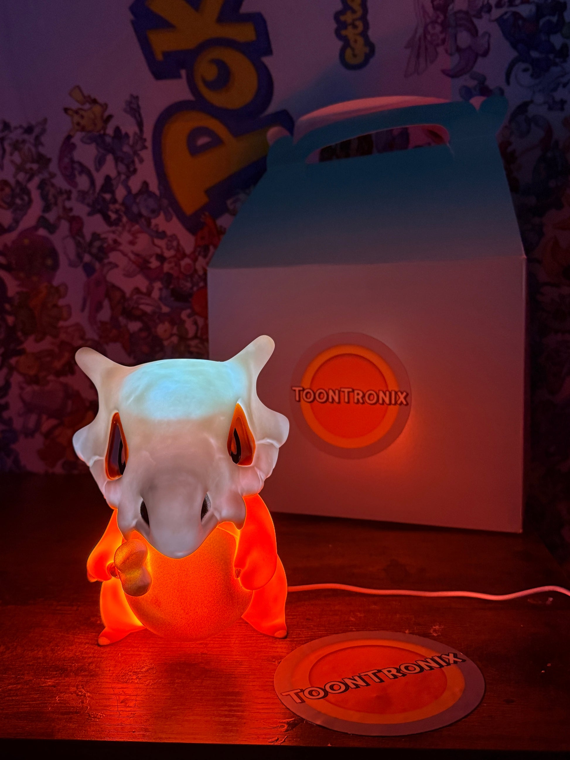 6" Cubone Pokemon statue desk lamp with built-in USB cord glowing orange light on wooden surface